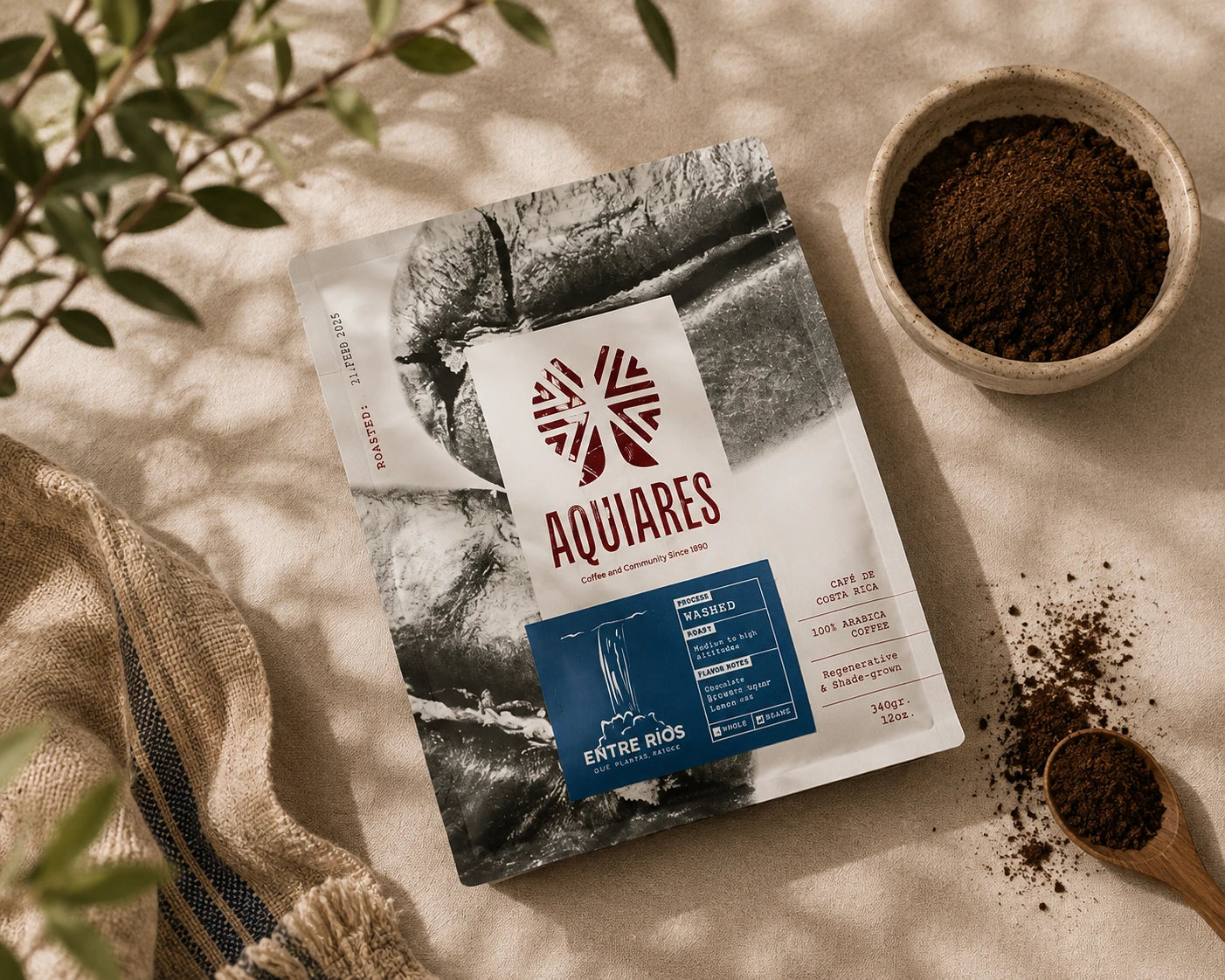 Aquiares Entre Ríos Costa Rican ground coffee displayed with freshly ground coffee, wooden scoop and natural linen in warm sunlight.