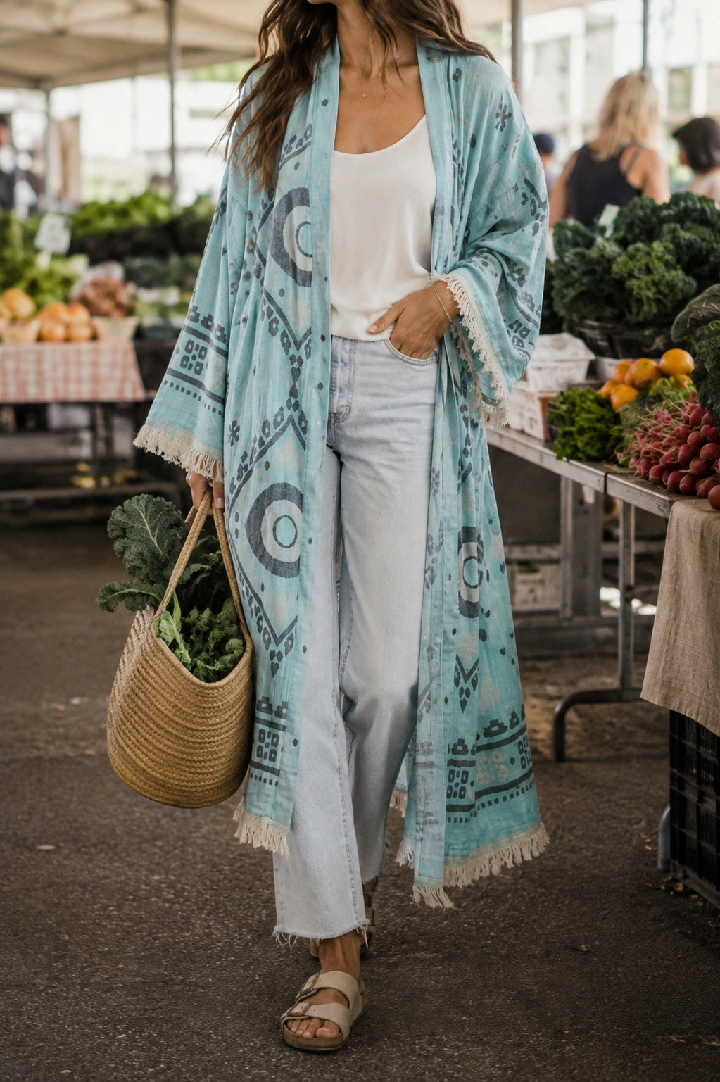 Woman styling the blue Ocean cotton kimono as an everyday layer with jeans and a white top while shopping at a farmers market.