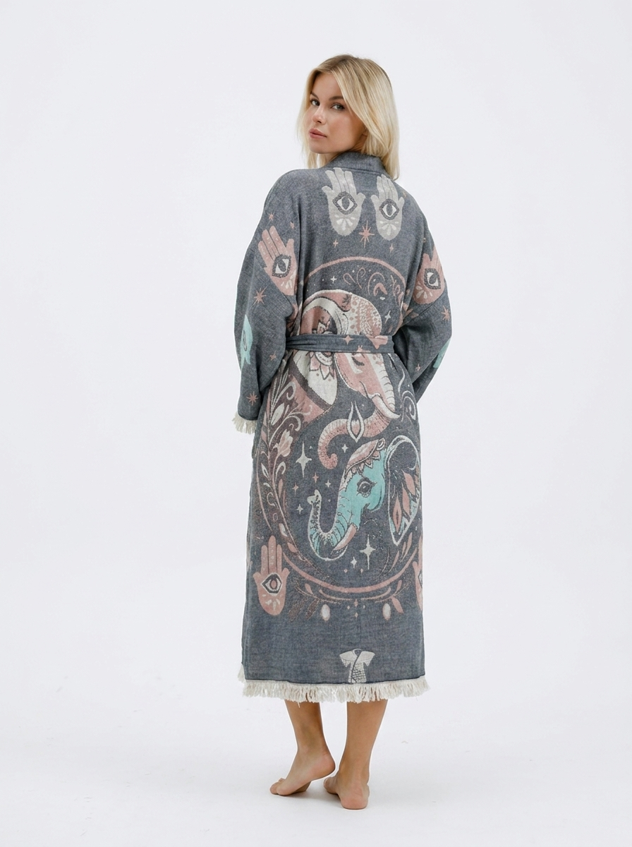 Full back view of a grey jacquard cotton kimono robe featuring large pink and turquoise elephant artwork, Hamsa hand symbols, evil eye details, wide sleeves, a matching belt, and cream fringe trim.