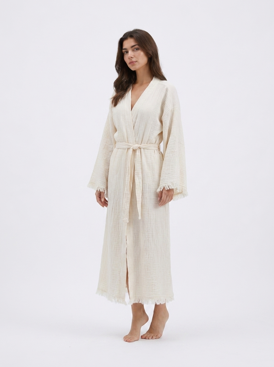 Front view of the Happy Horse cream natural cotton kimono robe with a relaxed ankle-length silhouette, wrap neckline, matching waist belt, wide sleeves, and delicate fringe trim.