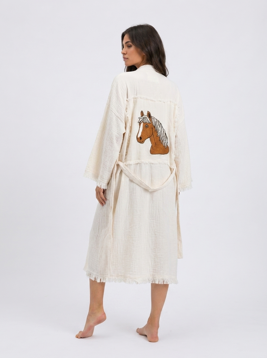 Full back view of the Happy Horse artisan-made cream cotton kimono robe with a large embroidered brown horse motif, patchwork-style back panel, relaxed long fit, matching belt, and fringe trim.