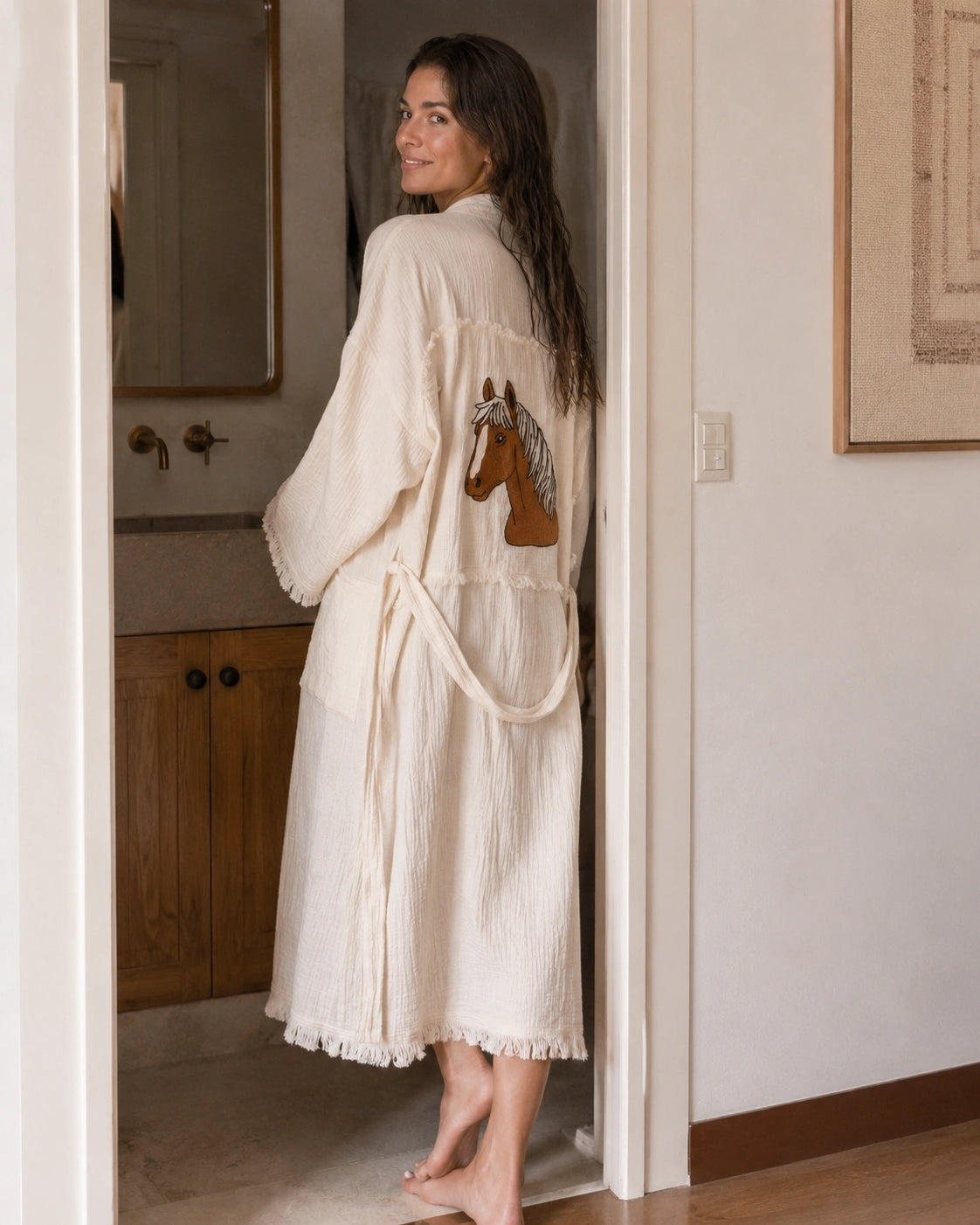 Woman with wet hair wearing the Happy Horse Muslin Kimono Robe after a shower, highlighting the soft textured muslin fabric, relaxed fit and horse embroidery.