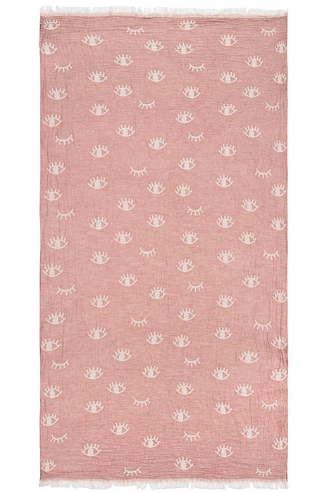 Full view of Lia rose 100% cotton Turkish peshtemal towel with a repeating ivory eye motif and fringed edges.